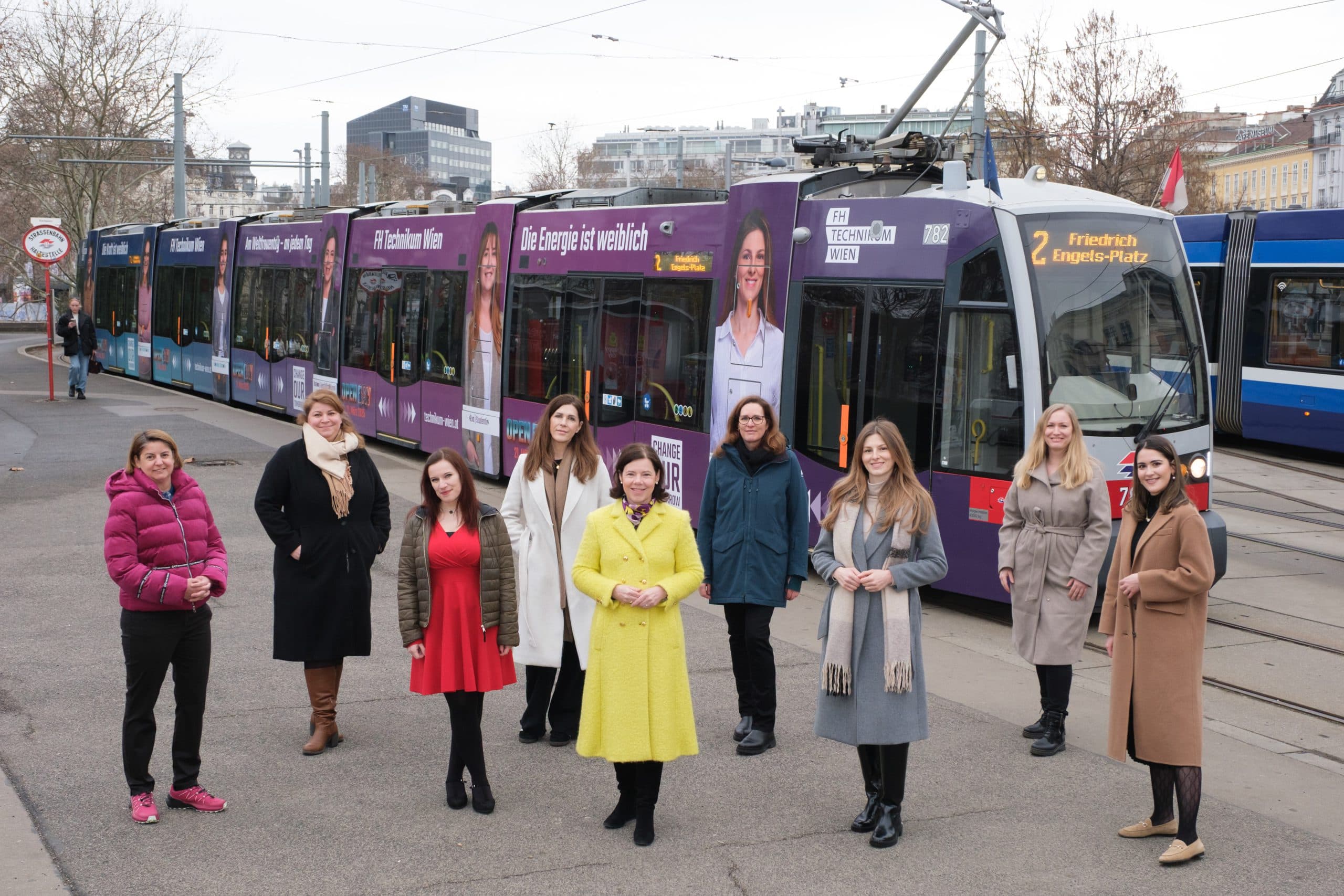 Gruppe von Frauen vor gebrandeter Straßenbahn